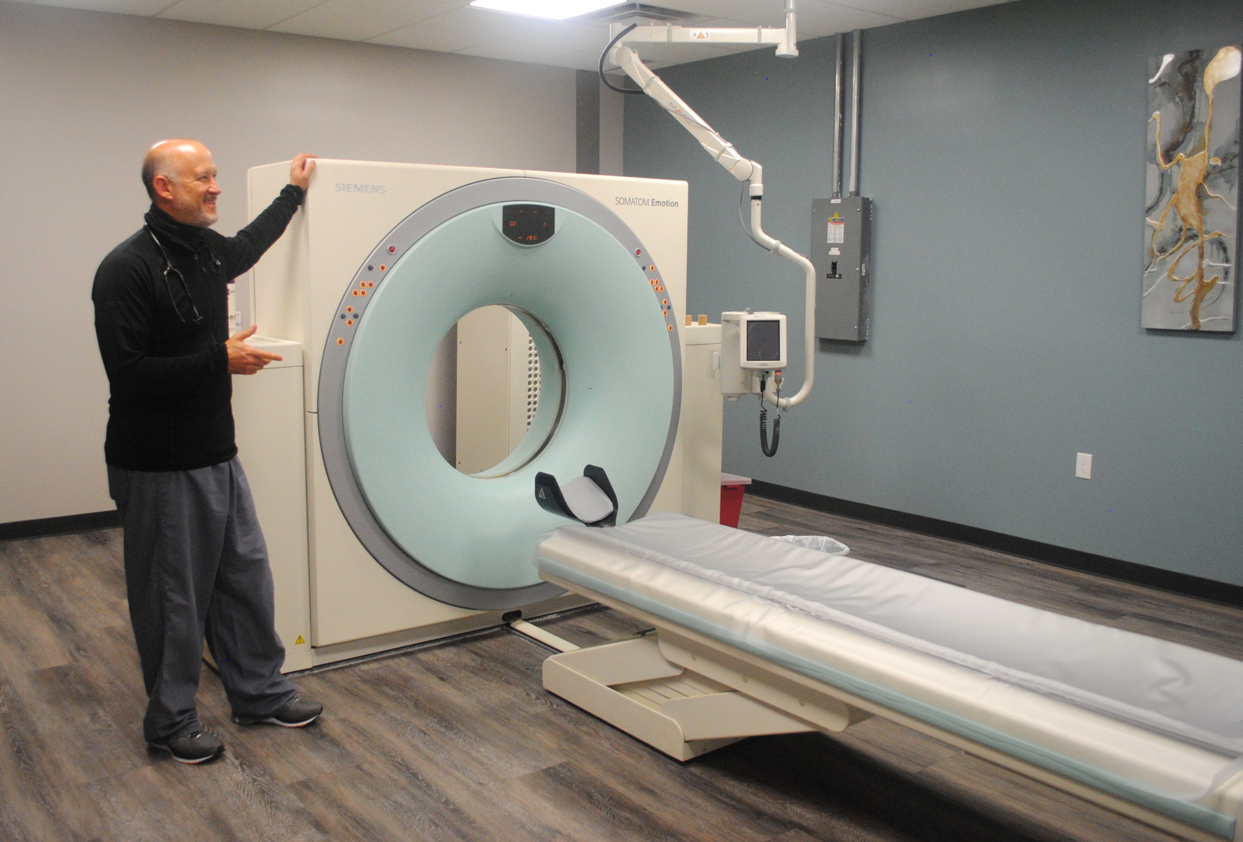 Dr. Mike standing next to CT scan machine
